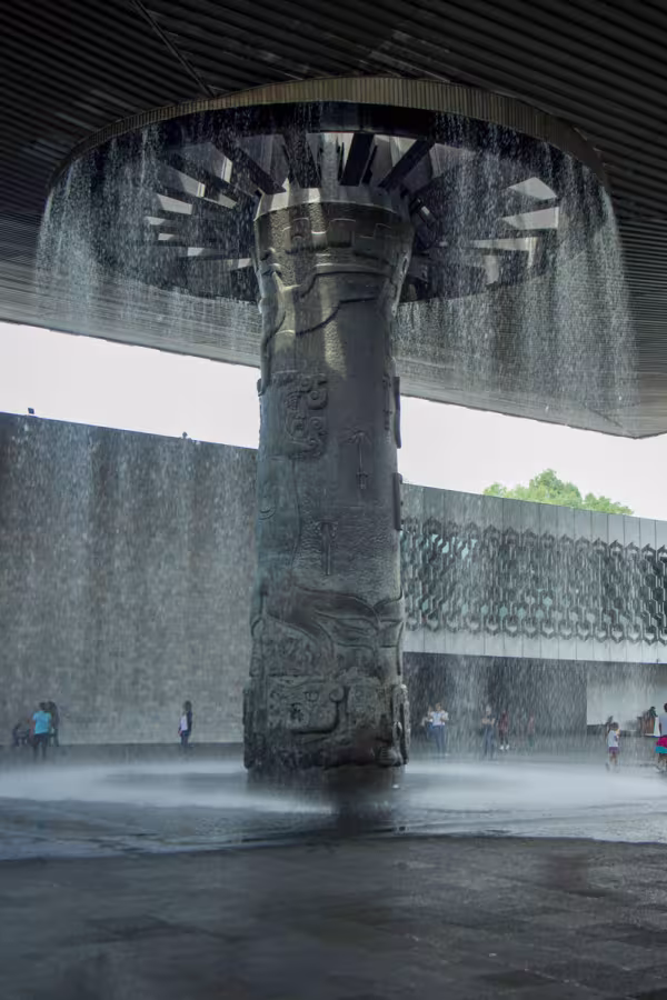 Den imponerande pelaren 'El Paraguas' på Nationalmuseet för antropologi i Mexico City. Här möts avancerad ingenjörskonst och konstnärlig symbolik i ett evigt vattenfall.
