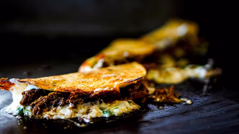 Quesabirrias på ett stekbord.