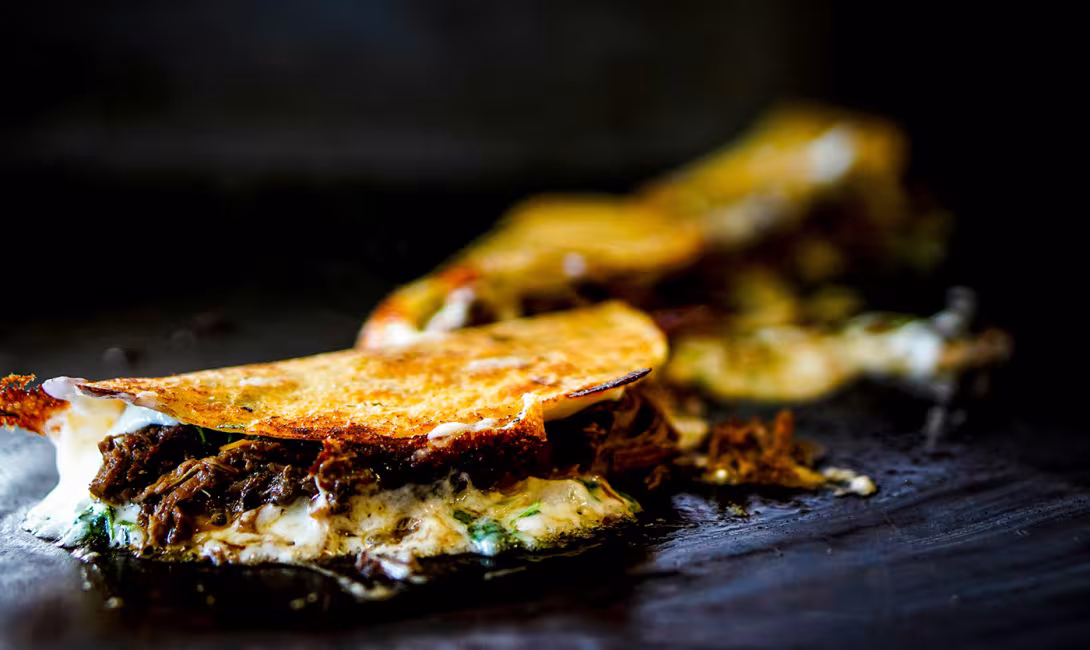 Quesabirrias på ett stekbord.